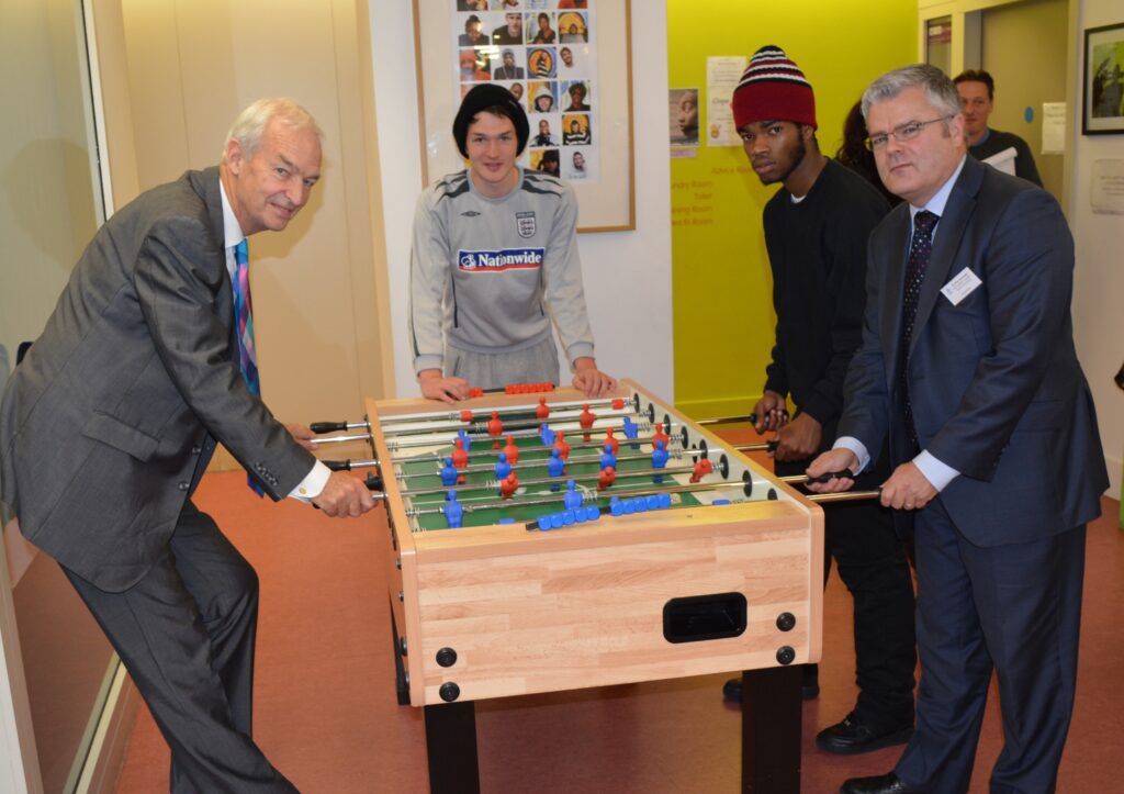 Jon snow and three others playing table football. A yellow wall is behind them