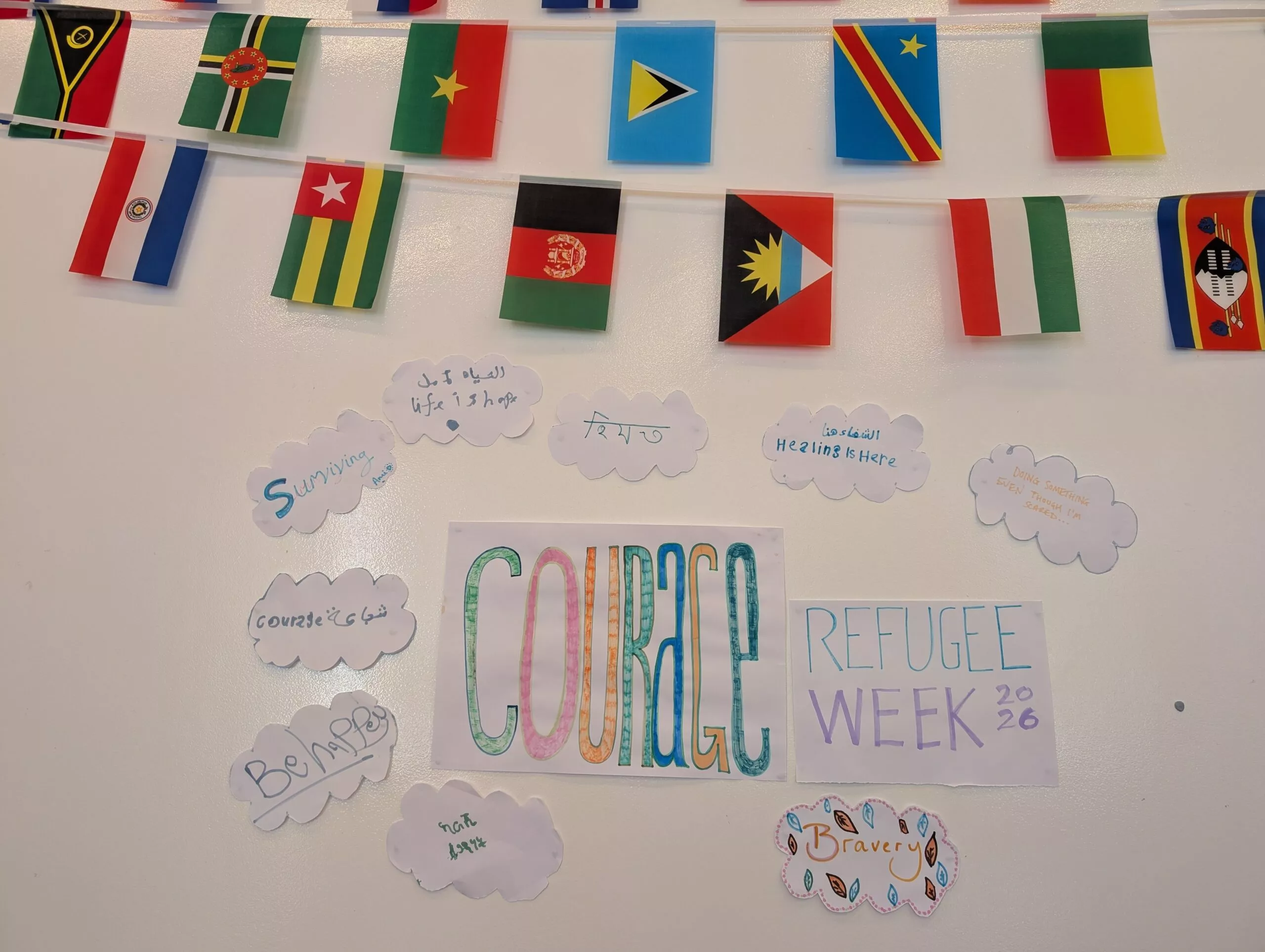 Photo d'un mur orné de différents drapeaux et du mot « courage » écrit en grosses lettres